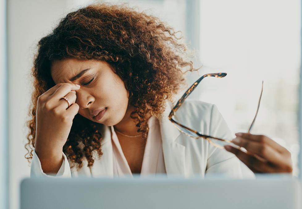 A woman with her glasses off dealing with eye pain