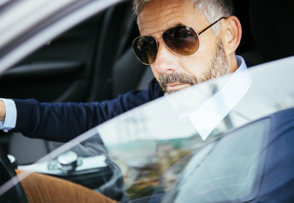 Man wearing sunglasses driving.