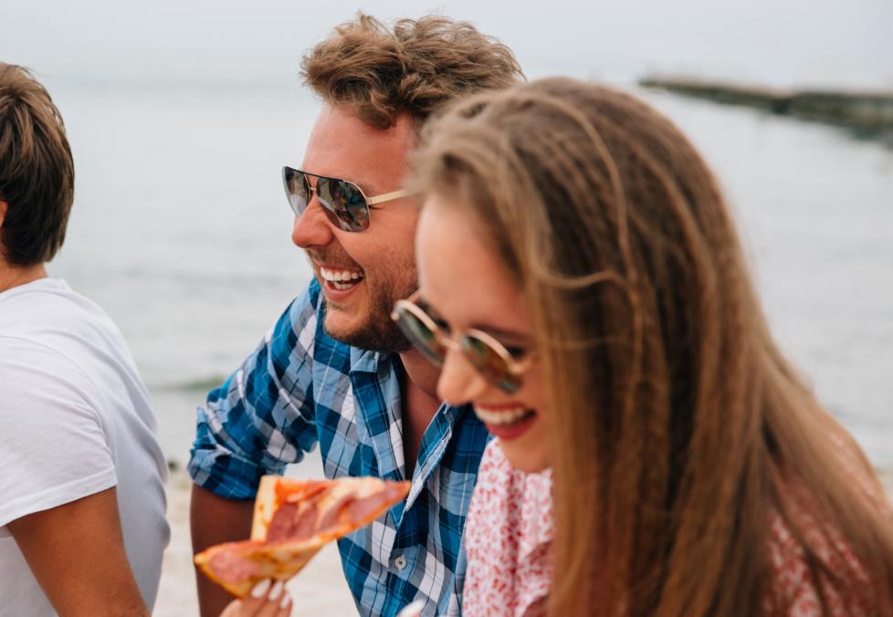 Your eyes still need sun protection on cloudy days. Friends hanging out near water wearing sunglasses.