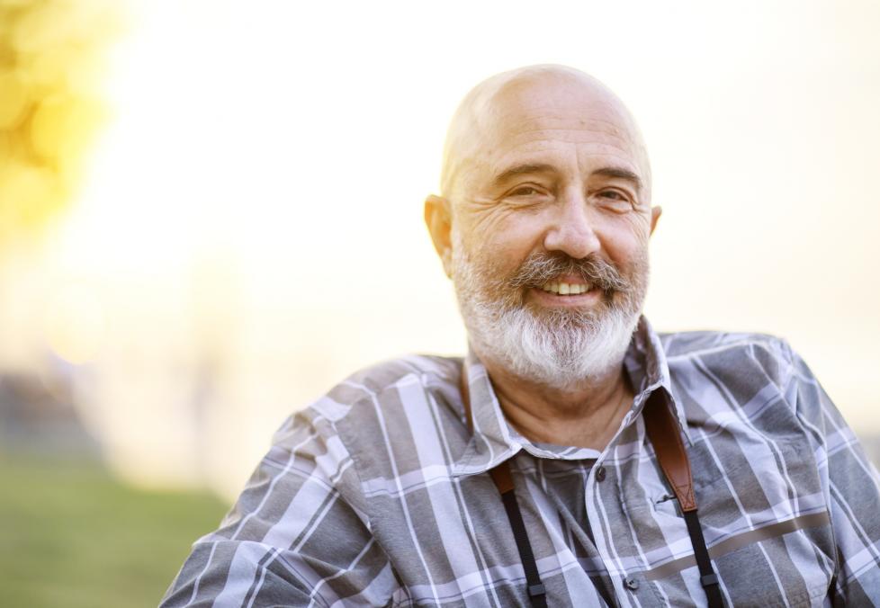 A smiling man looking into the camera with a sunset in the background