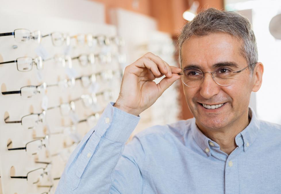 Middle-aged man trying on glasses for a story on the best glasses for square faces