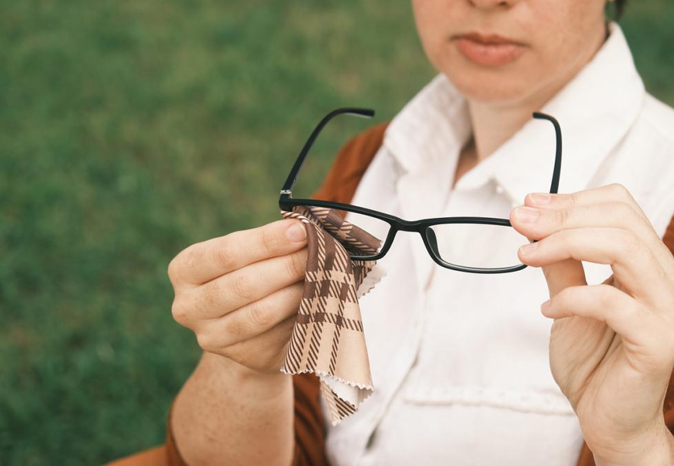 Women cleaning her glasses with a microfiber cloth