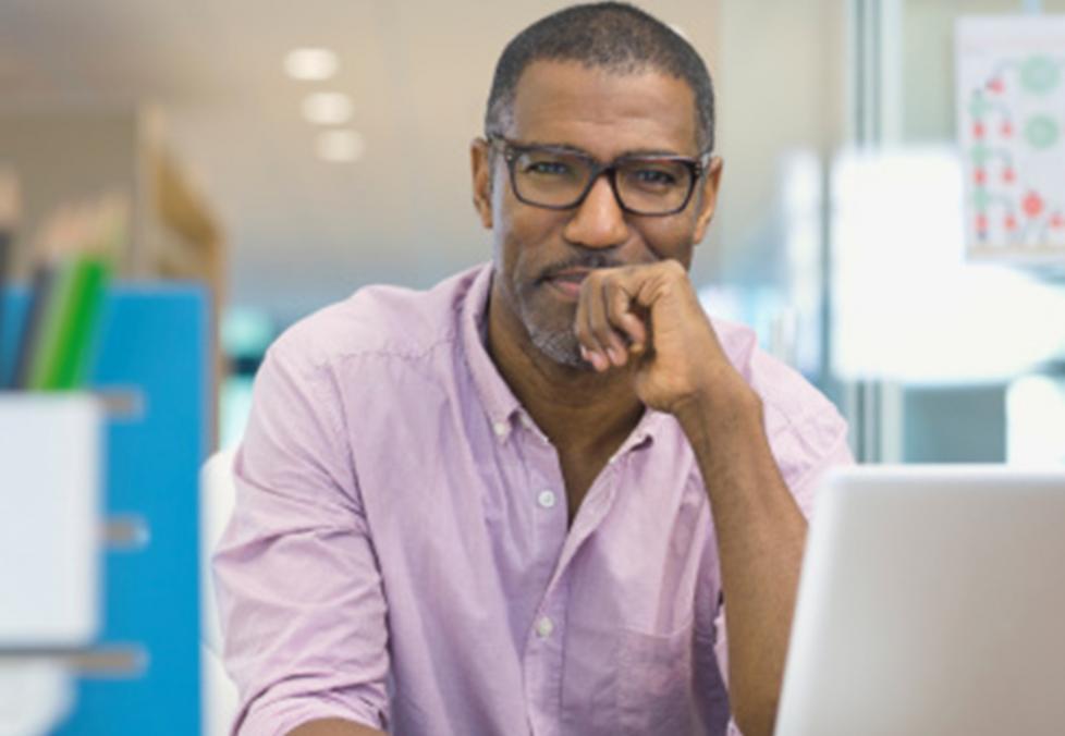 Person with bifocal glasses in front of a laptop