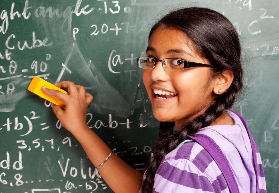 Child with eyeglasses cleaning the blackboard