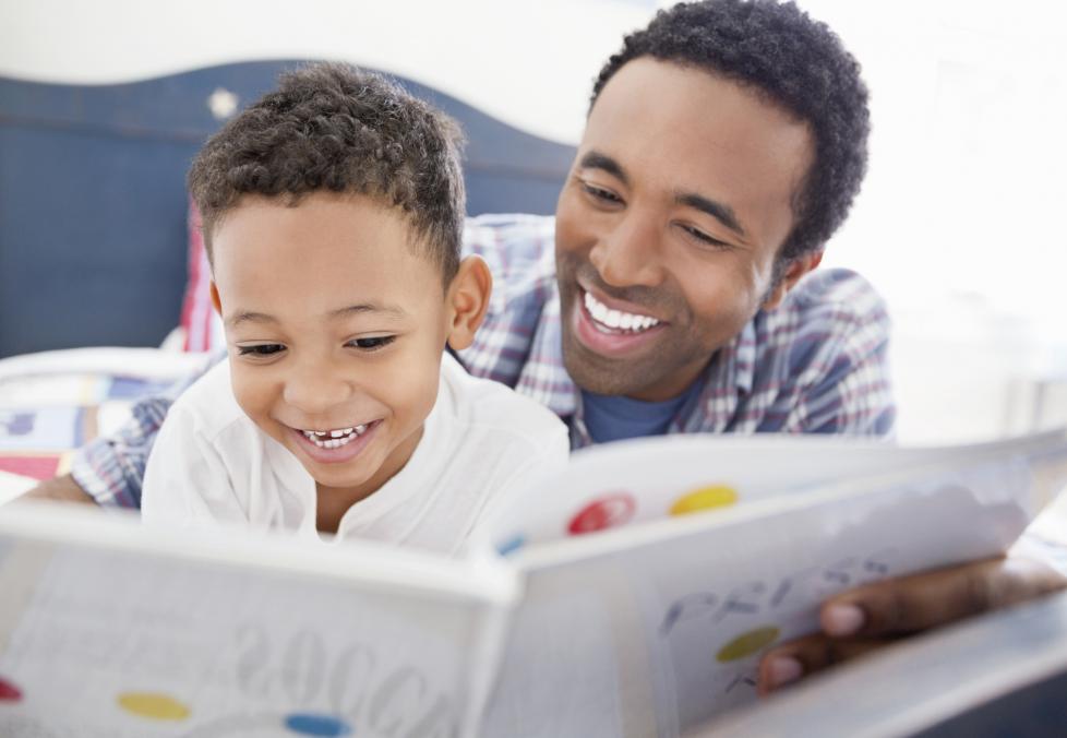 Father and son reading a book together.