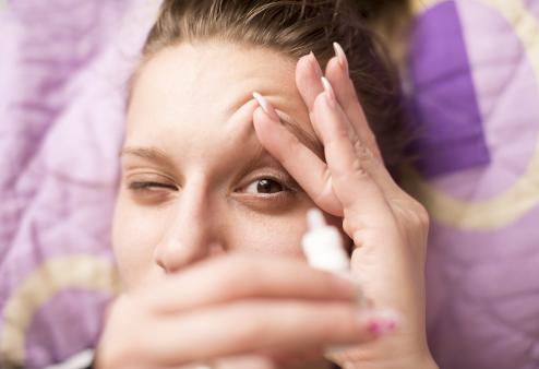 Woman using eye drops