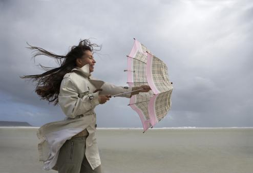 Woman struggling with umbrella.