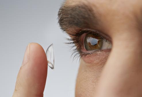 Woman placing contact in eyes