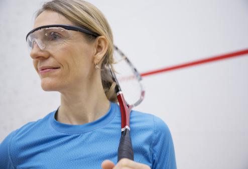 Wearing the right sports eyewear can keep you safe so you can have more fun. Woman holding racquet wearing safety eyewear.