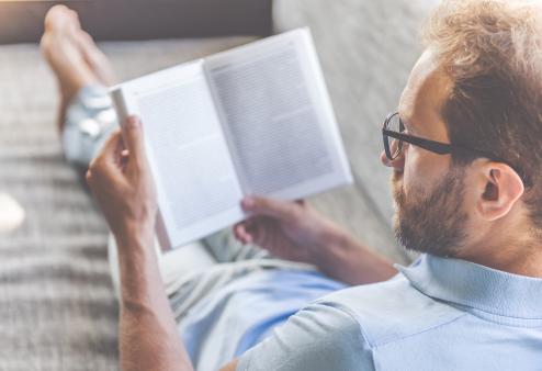 A man with glasses reading a book