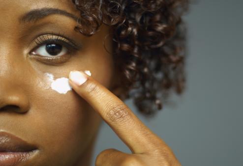 A woman applying eye cream