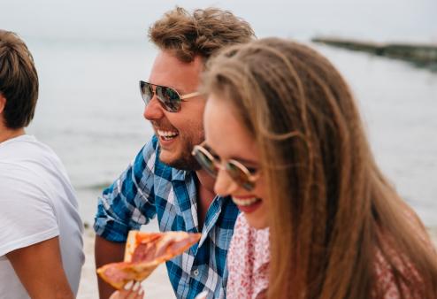 Your eyes still need sun protection on cloudy days. Friends hanging out near water wearing sunglasses.