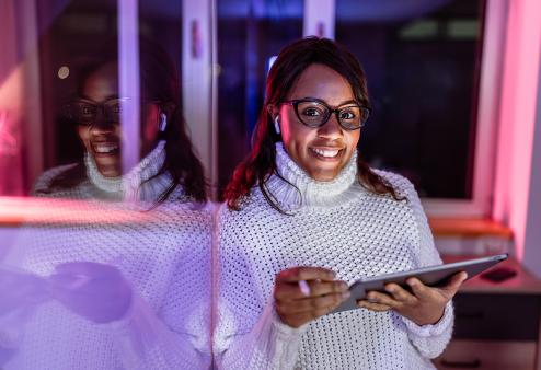 A woman with glasses holding a tablet in a store