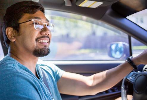 Young adult male wearing glasses and driving for a story on what is 20/40 vision