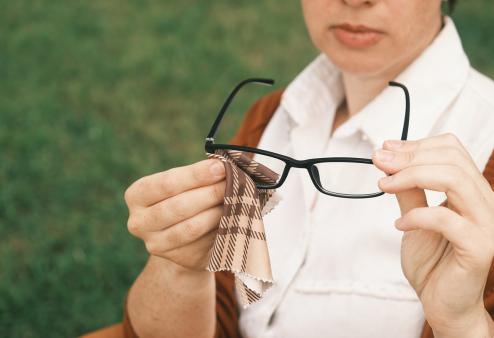 Women cleaning her glasses with a microfiber cloth