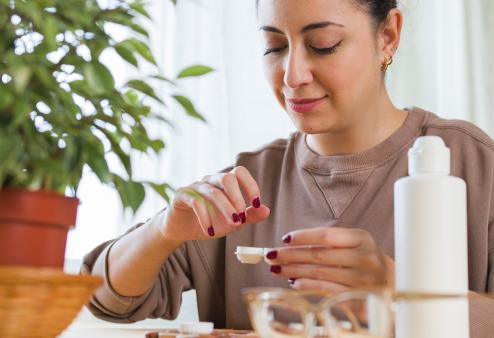 Women putting contact lenses in solution