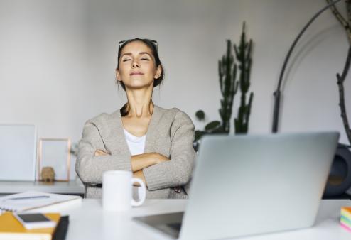 Woman working on laptop, resting her eyes.