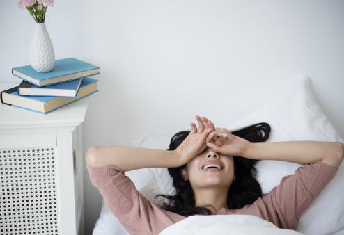 women in bed drying off eyes