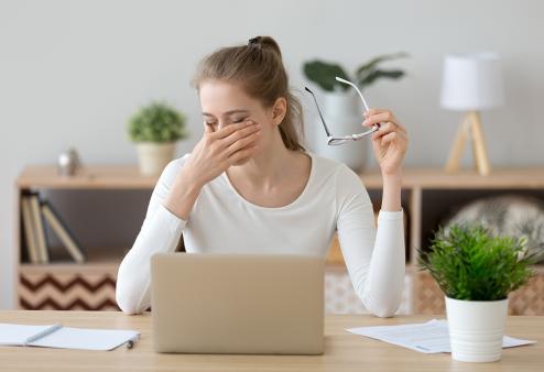 Woman taking off glasses and rubbing her eyes